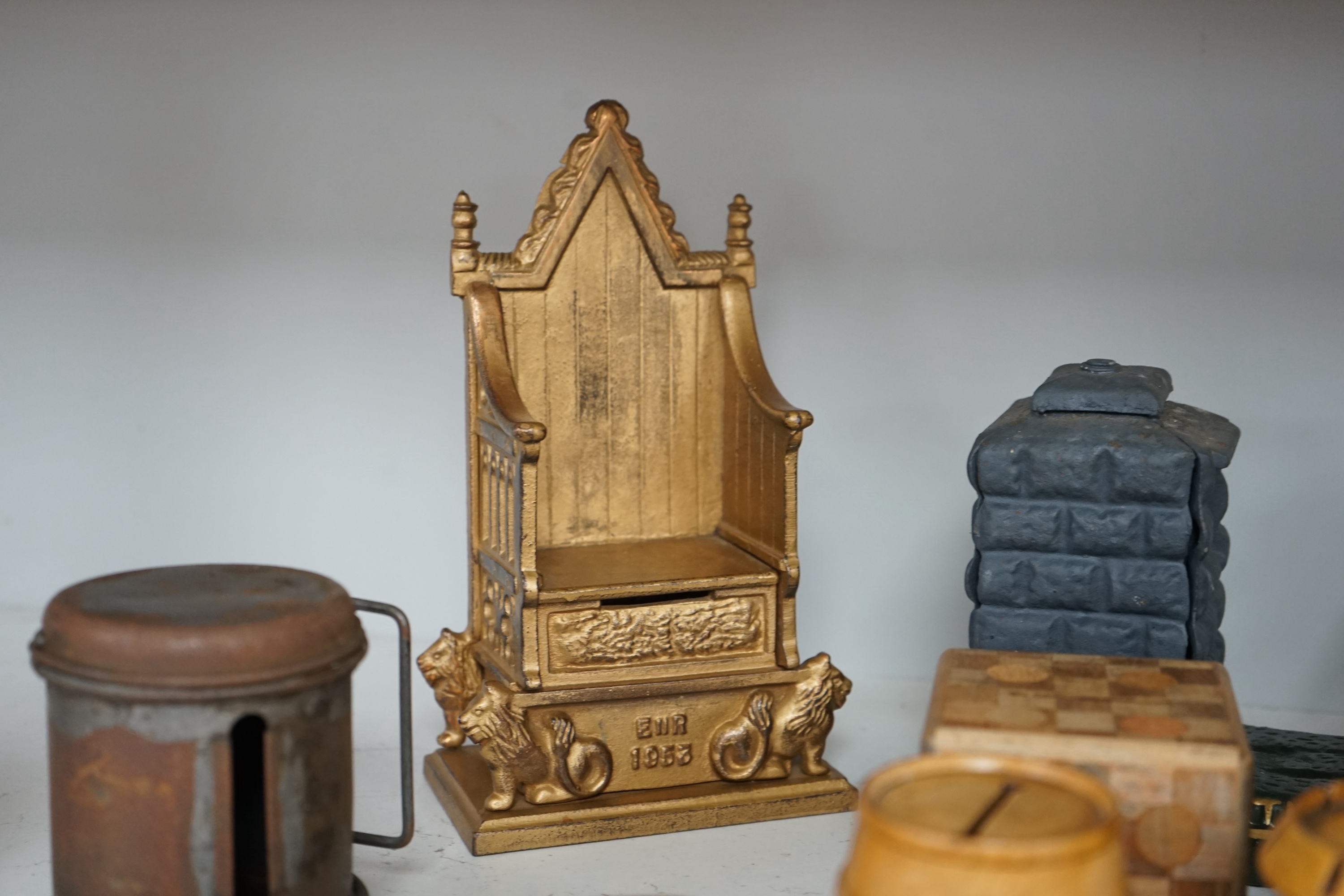 A collection of mixed tin wood and ceramic money boxes to include Cadbury’s milk chocolate, three in the form of trunks and a ceramic pig. Condition - varies